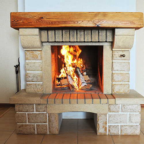 Stock photo of fireplace changeout.  Beautiful large wooden mantel the fire box surround has a unique stone and their is a box underneath in the middle of the heart to store wood.