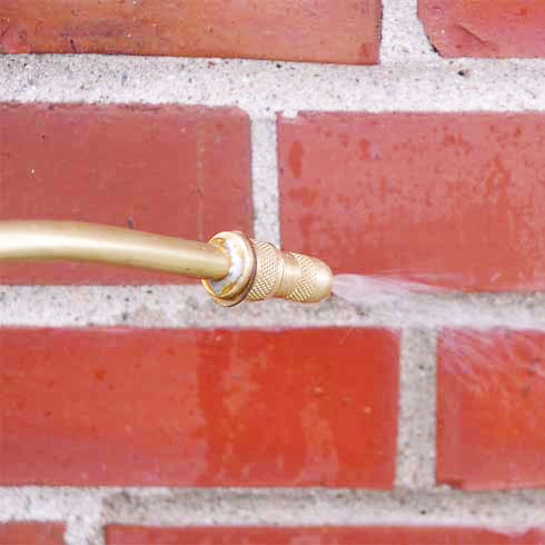 Stock photo of water repellent spray on bricks with nozzle and sprayer.